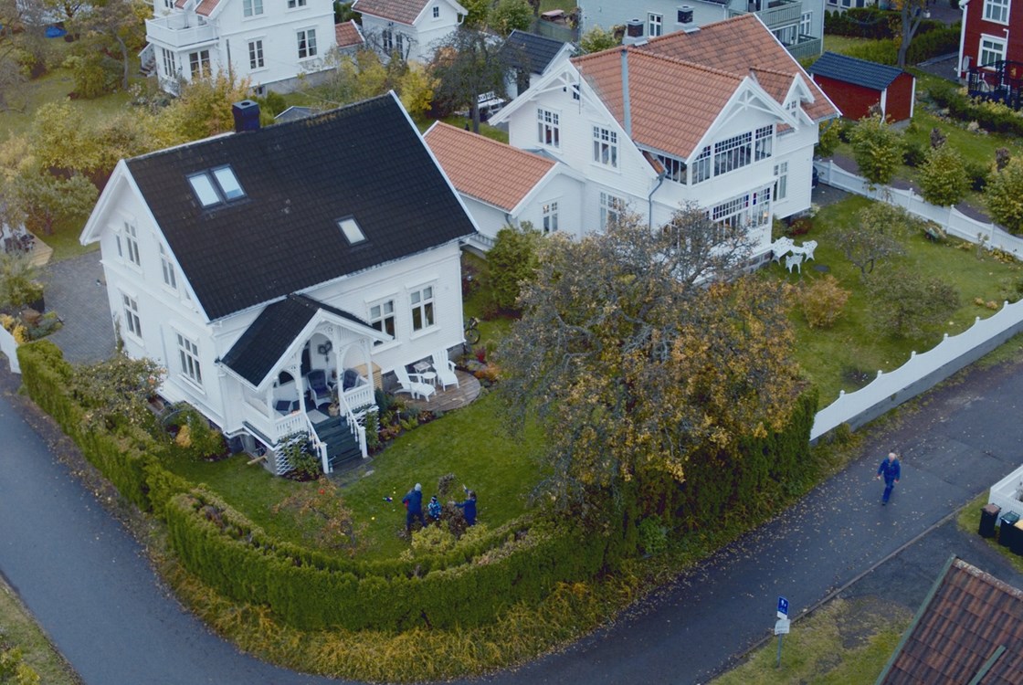 Hjemmekontor med tre etasjer, garasje og solrik tomt med epletrær.