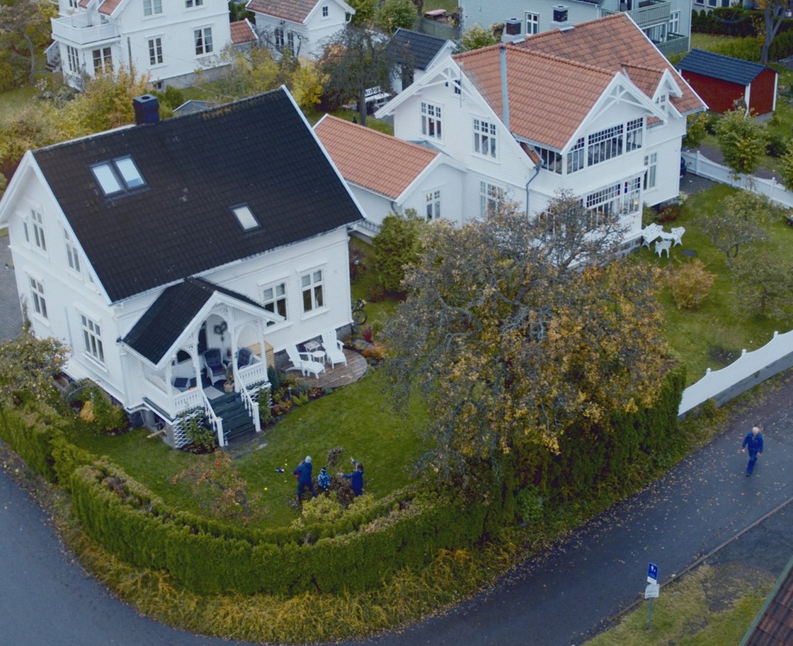 Hjemmekontor med tre etasjer, garasje og solrik tomt med epletrær.